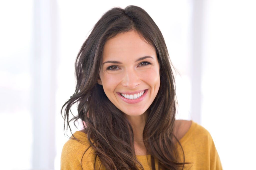 Brunette woman smiling with dental crowns in The Woodlands