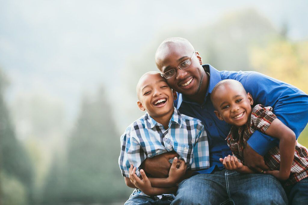 Father hugging his two sons after visiting their family dentist in The Woodlands