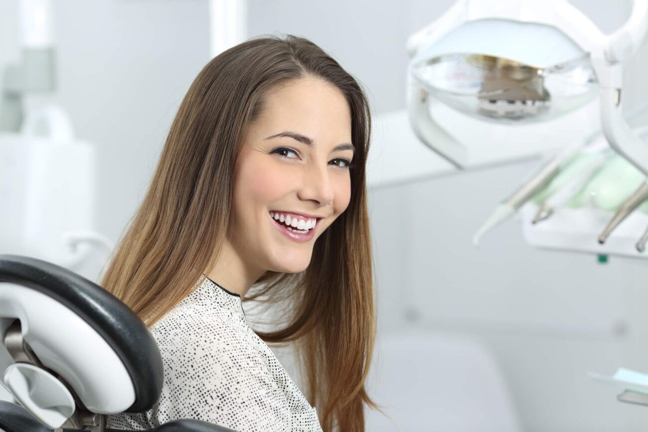 Woman smiling in dental chair after getting dental fillings in The Woodlands