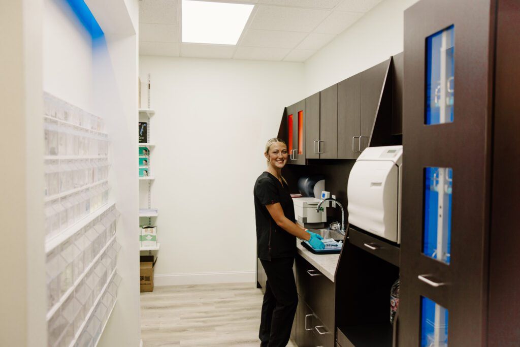 Dental team member smiling while washing her hands at dental office in The Woodlands