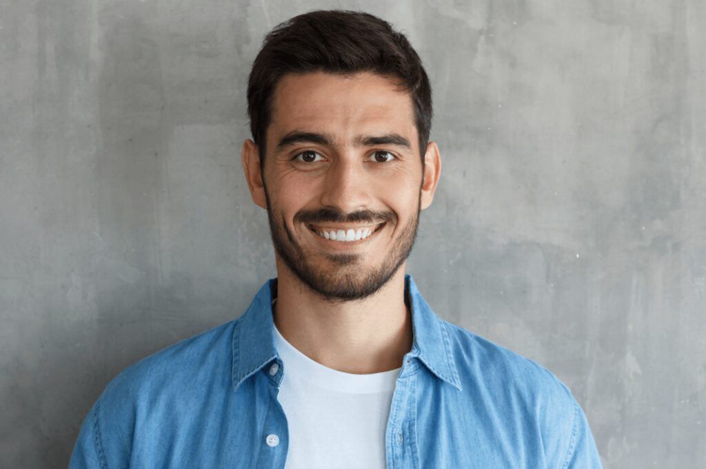 Young man grinning after gum disease treatment in The Woodlands