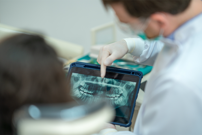 A dentist showing a patient her X-rays