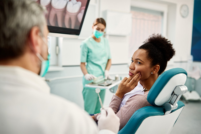 Woman with toothache sitting in treatment chair