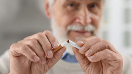 A man breaking a cigarette in half