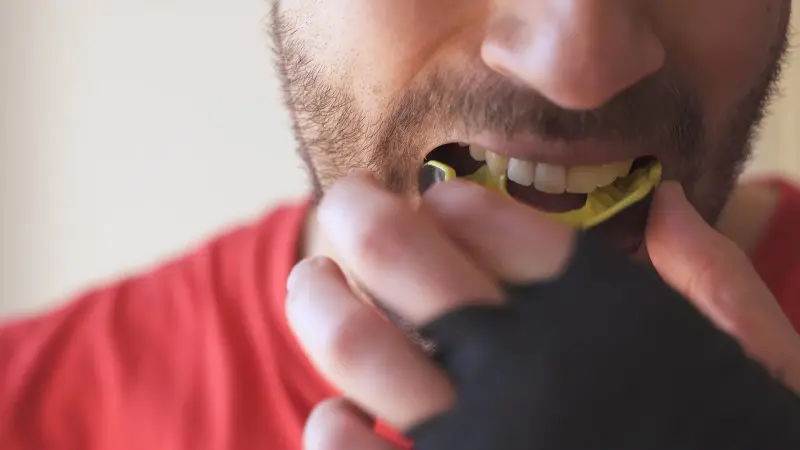 Man inserting a custom mouthguard before playing sports