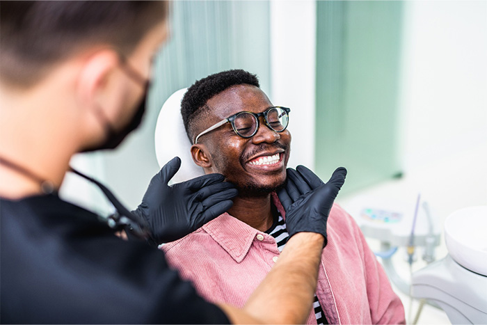 Dentist looking at patient's smile in treatment room.