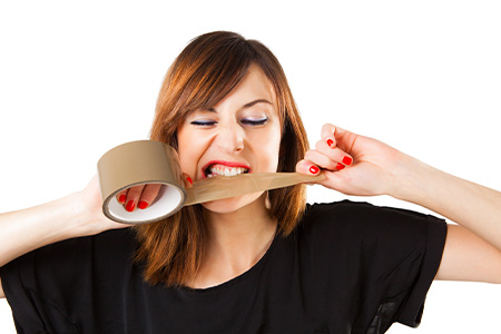 Person tearing duct tape with their teeth.